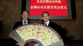杨受成博士获国家体育总局局长刘鹏（左）赠送一把齐集所有金牌运动员签名的纸扇。