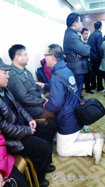 安置区内，面对痛哭的家属，一名志愿者双膝跪下安慰，连说“要坚持，要坚持” 摄/法制晚报记者 洪煜 刘汩 易朵 柴程