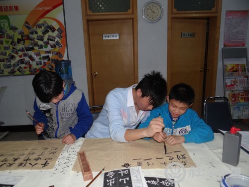 书法志愿者教小朋友写毛笔字