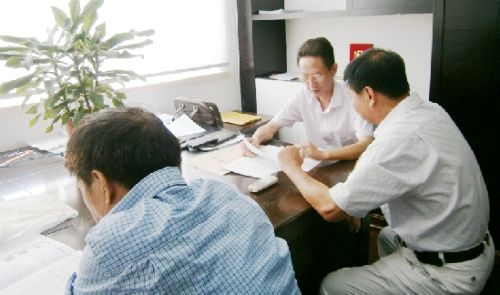 老周（中间）在工作室里帮当事人调解纠纷。通讯员 徐美桔 摄