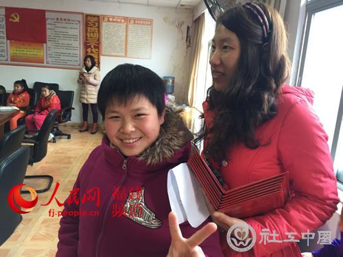 福利院的“大孩子”黄海跑去和比她年级小的社工吴爱雁合影。 林长生 摄