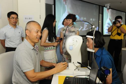 拍片师在为参会人员拍眼底照