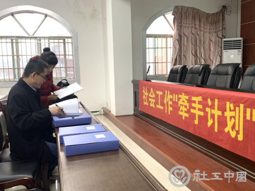 调研组在新宁县查阅“牵手计划”项目资料