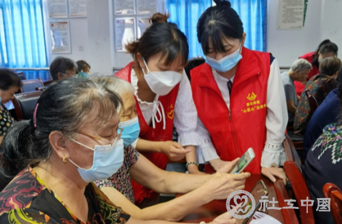 社工教老人学习使用智能手机。通讯员  黄娴  摄
